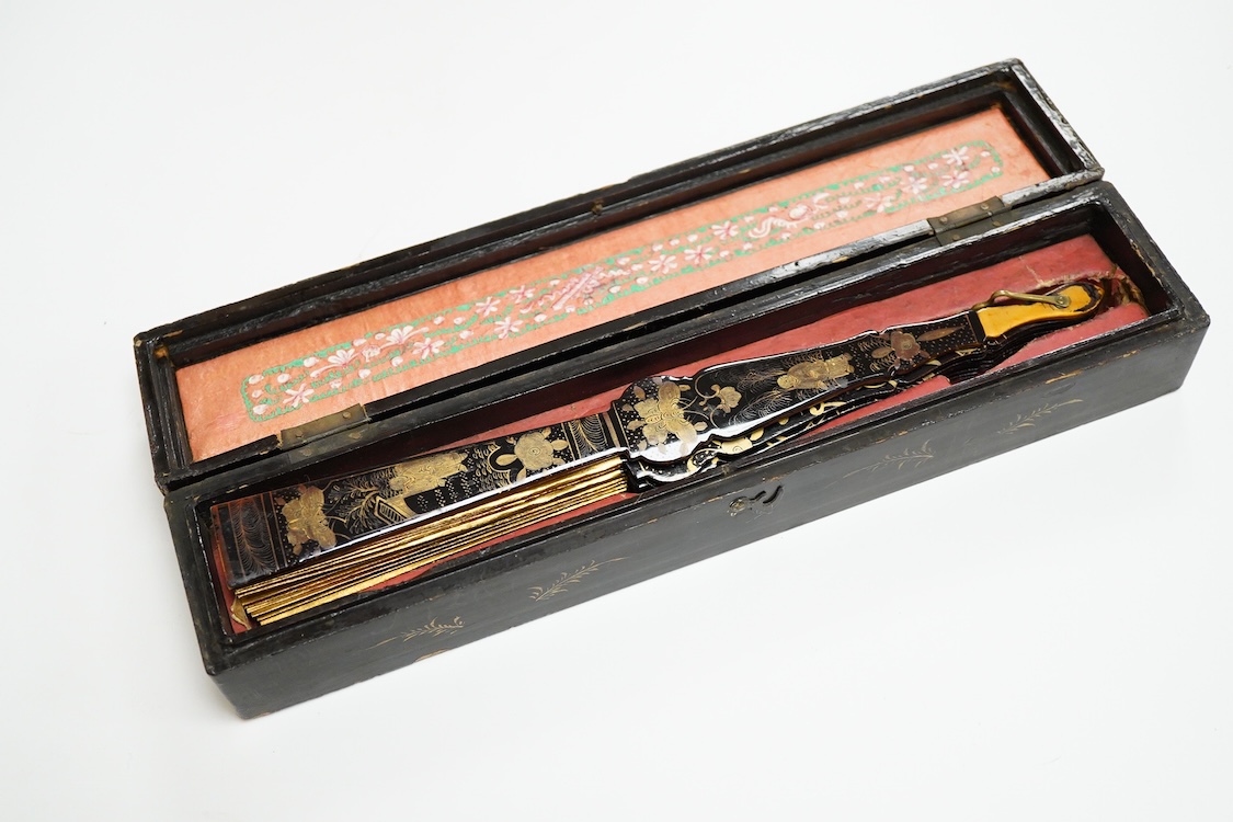 Four 19th century Chinese gilt-decorated black lacquer fans with figure painted leaves, two cased, largest 41cm